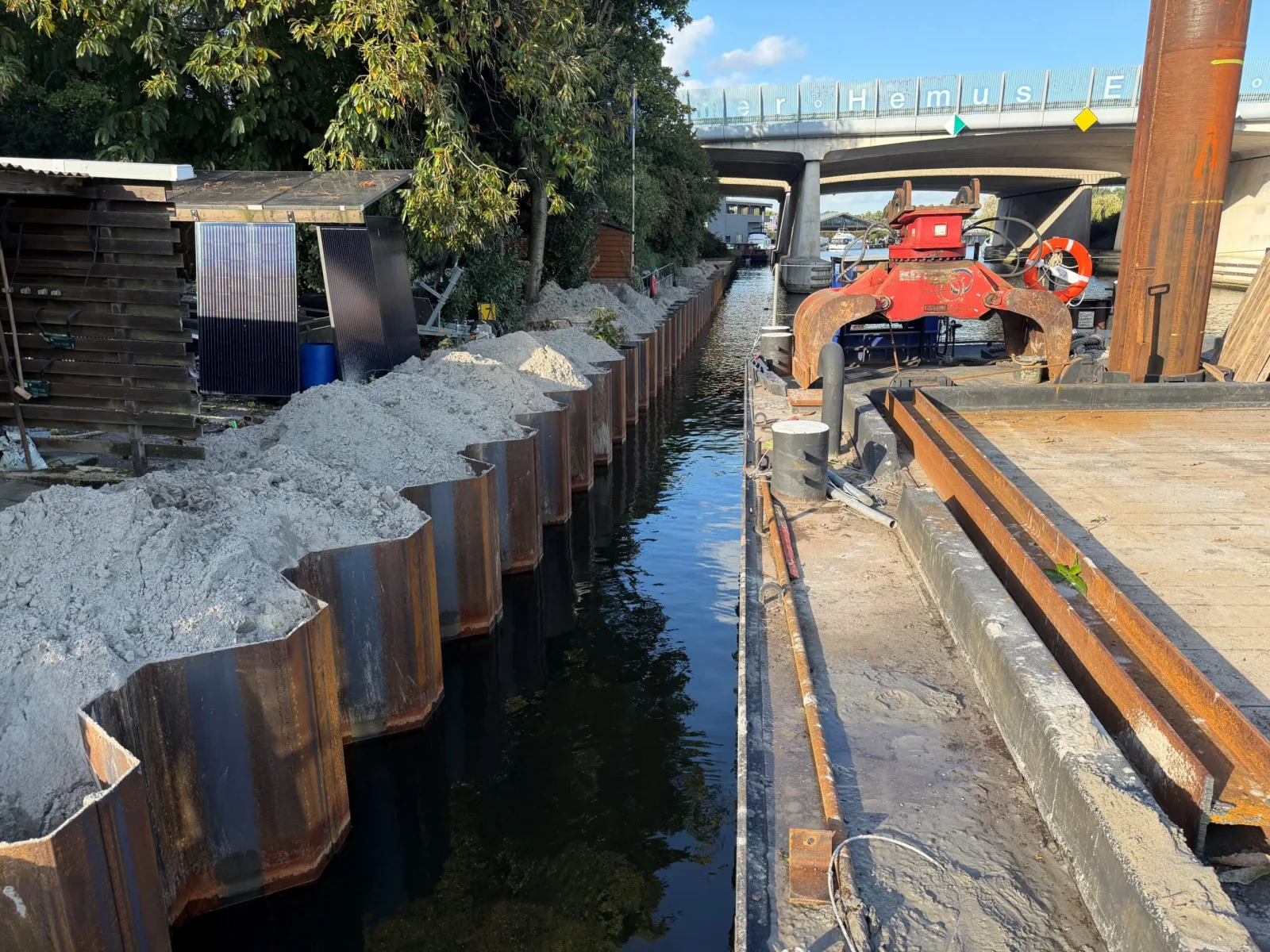 Nieuwe stalen damwand langs de kade in Baarn, aangevuld met zand